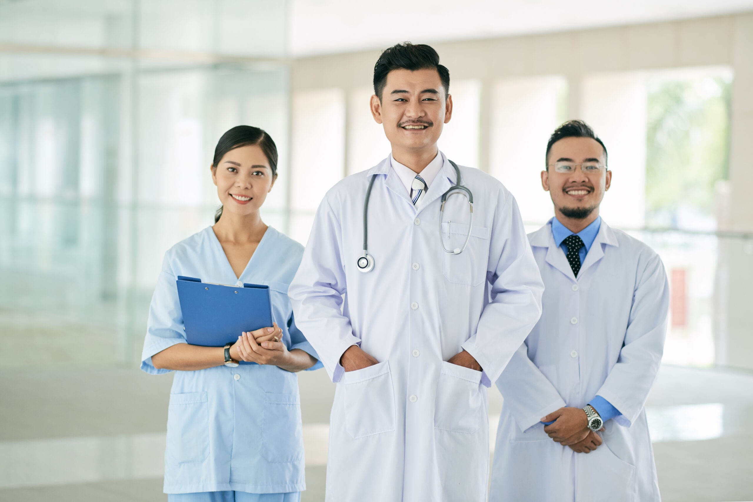 Happy Vietnamese medical team of three smiling at camera